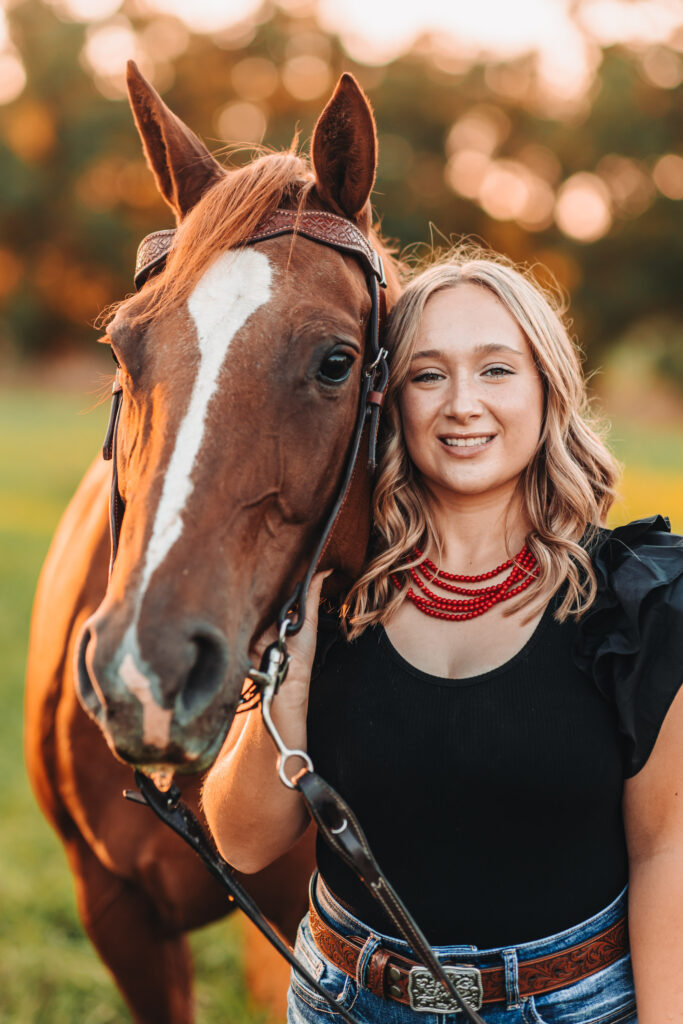 A high school senior standing with her horse during her senior photography experience.