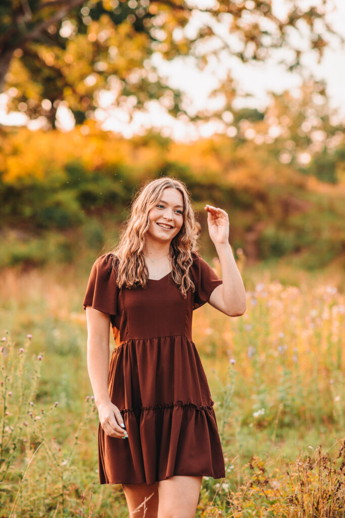 A high school senior walking in a field during her senior photography experience.