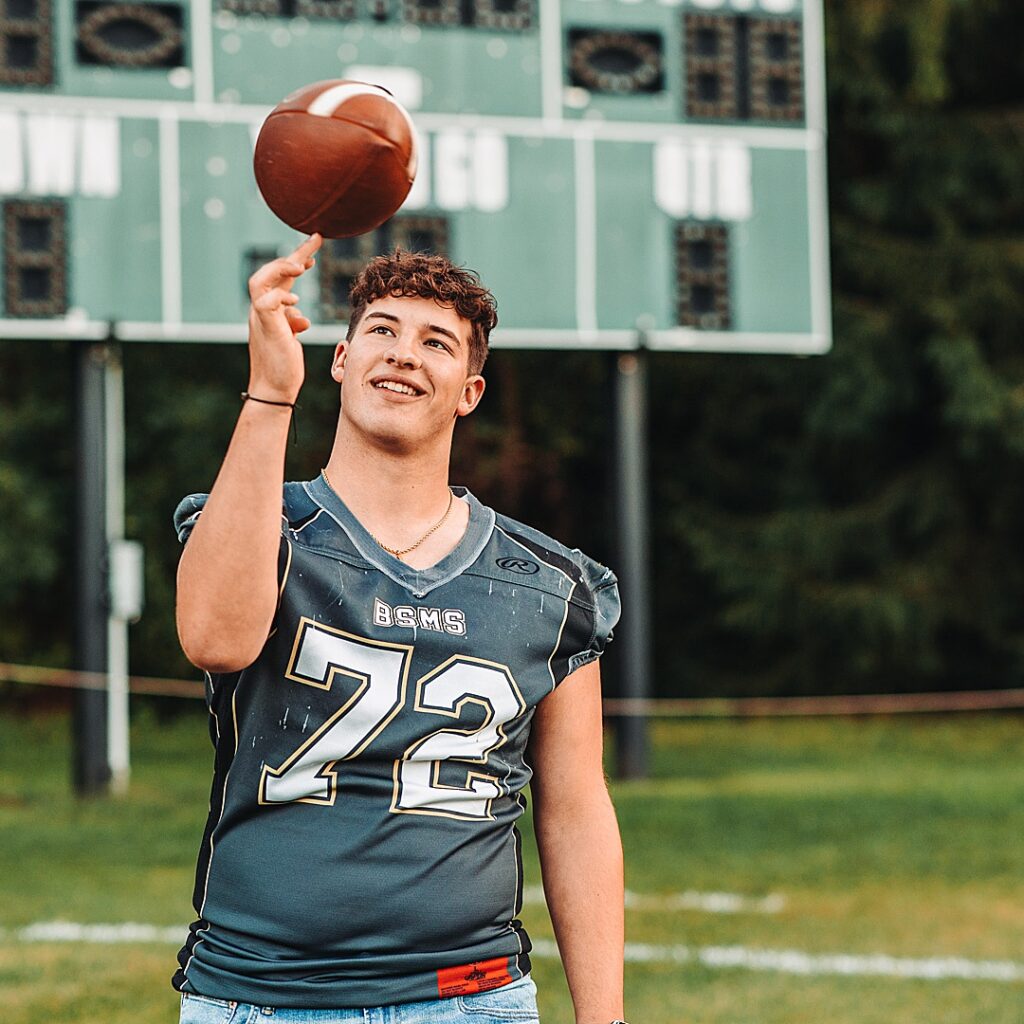 Senior football player playing with the football during his senior session
