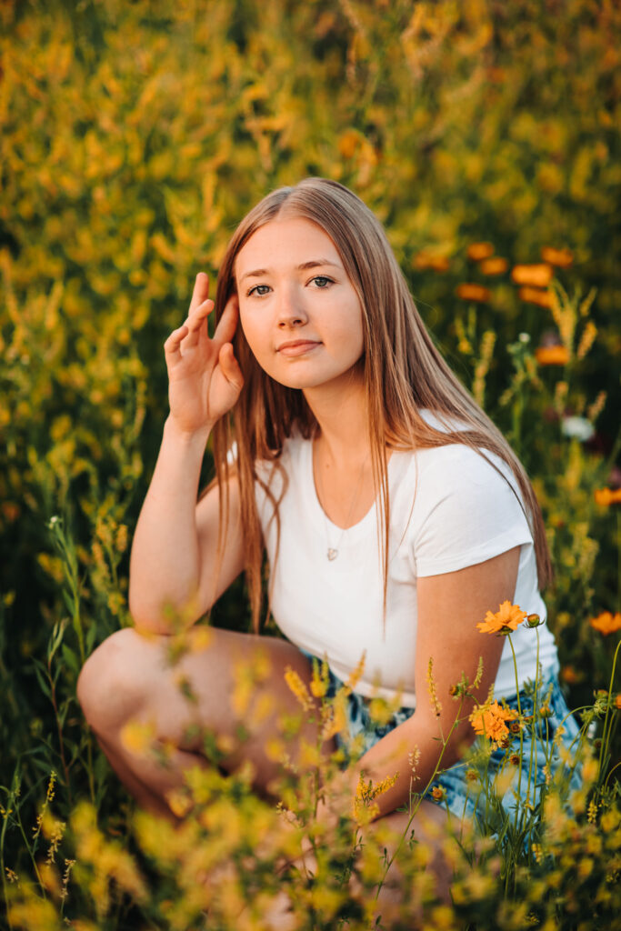 A high school senior in a flower field during her senior photography experience.