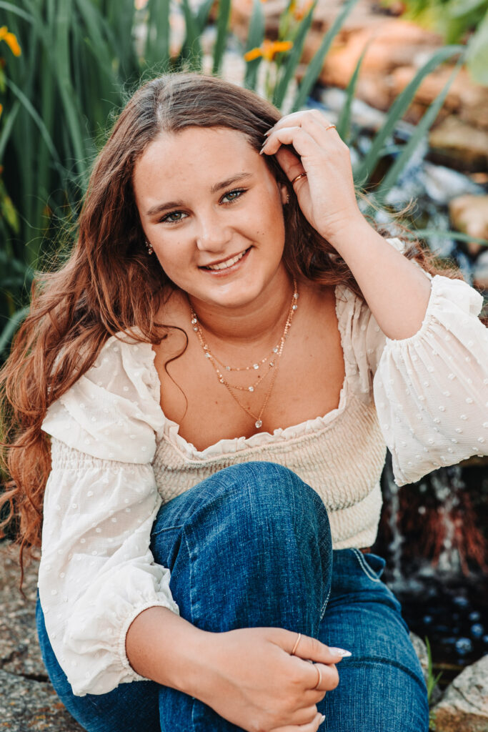 Close-up of Megan posing near a water feature in her neighbor’s backyard