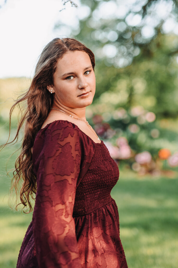 Megan standing tall in tall grass, showcasing her Western-style outfit