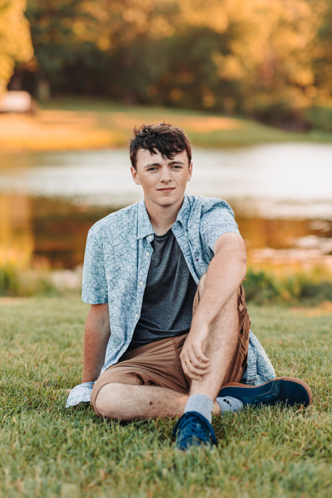 Ian Wacker’s senior portrait with lush pasture fields in the background