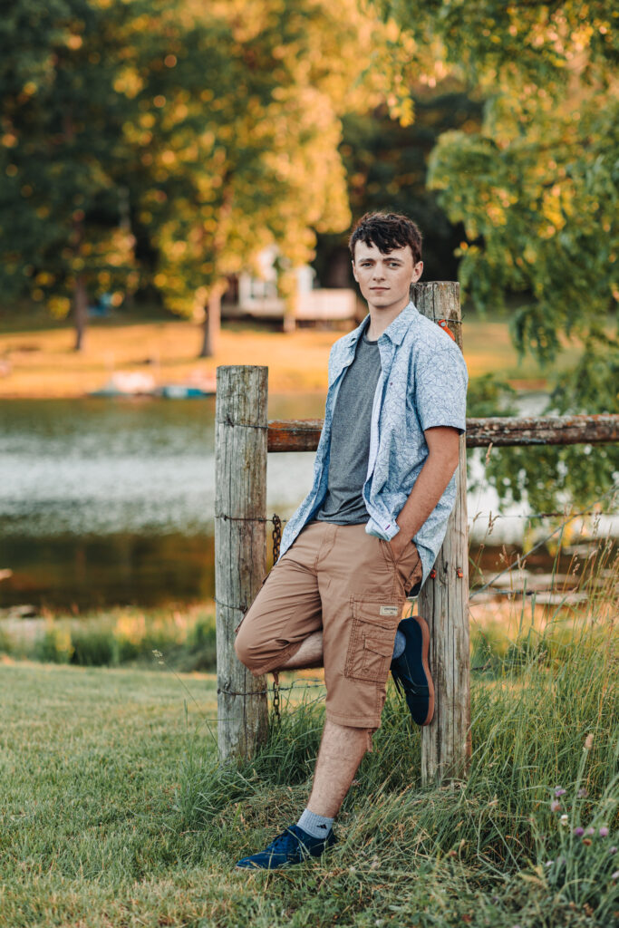 Ian Wacker posing by the scenic pond under a sunny sky