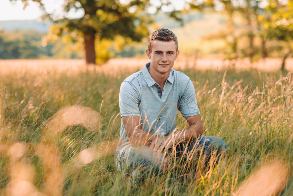 belmont wisconsin high school senior guy sitting in a tall grassy field