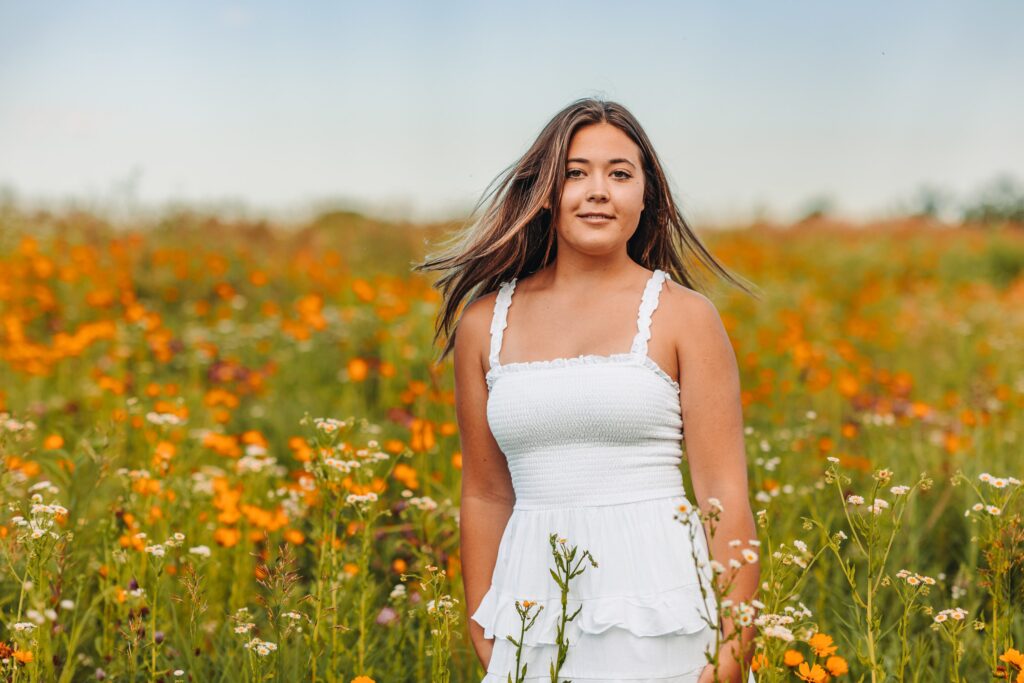 high school senior girl in field with flowers