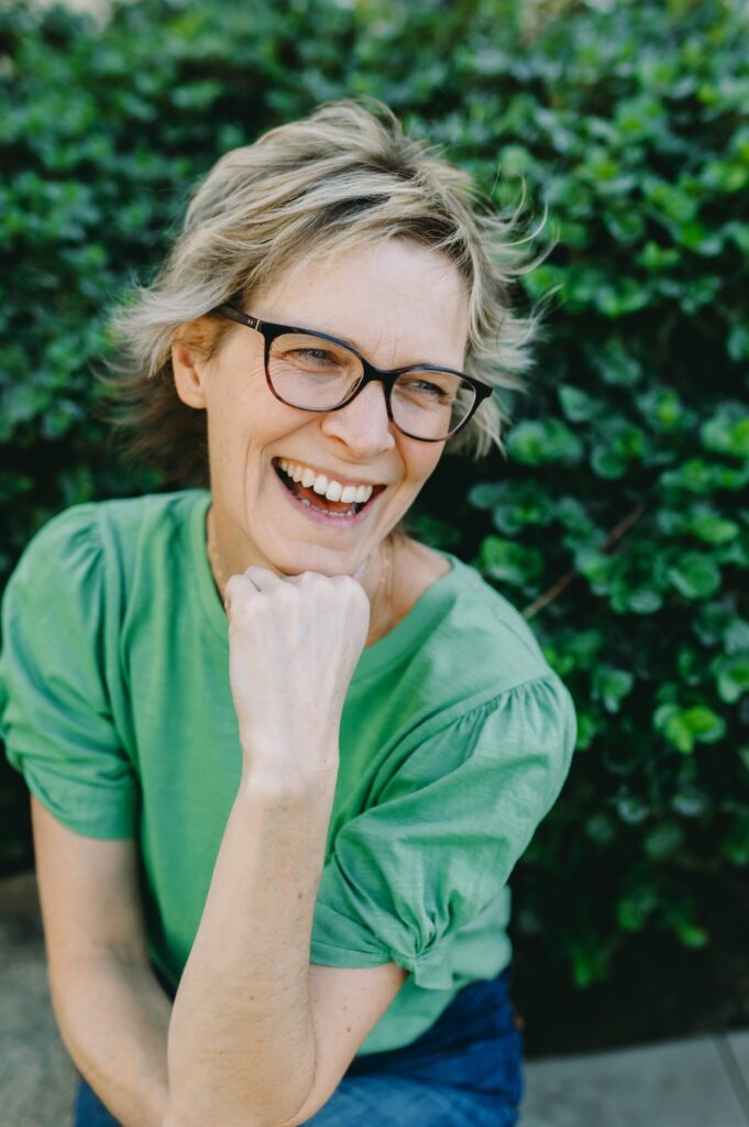 sarah monson photography sitting in front of a green bush