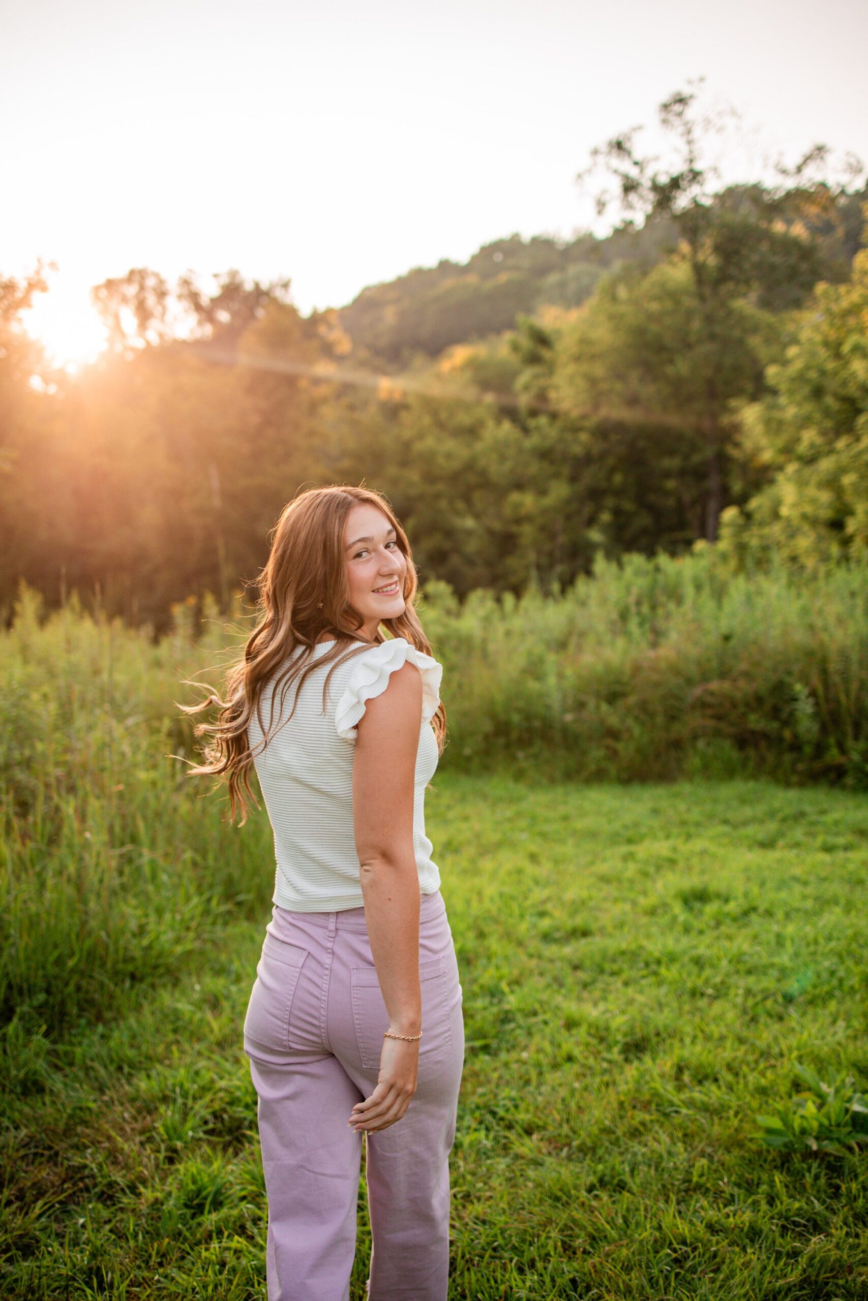 Benton High School senior Ries holding a flower bouquet in soft evening light at Swiss Valley.